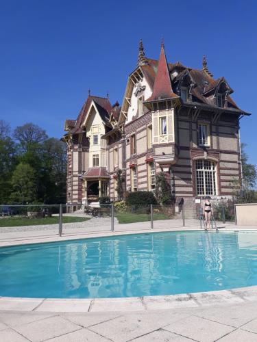 伊帕特河畔巴泽科特Château de la Râpée Hôtel restaurant的一座大房子,前面设有一个游泳池