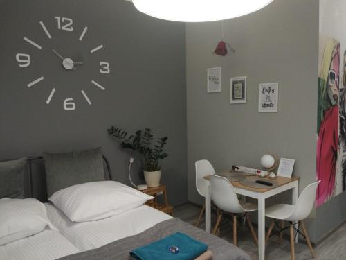 弗罗茨瓦夫Apartament Easy Stay Center的卧室配有一张床,墙上挂着一个钟