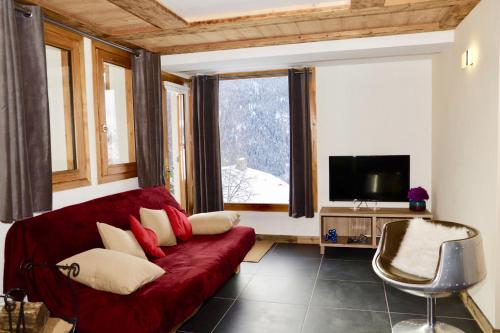 佩塞克鲁瓦Le Falyoucher的客厅设有红色的沙发和窗户。