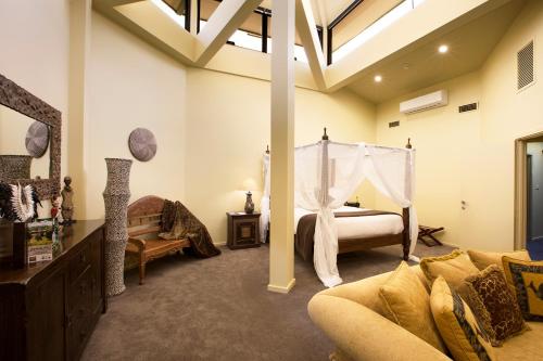堪培拉贾马拉野生动物山林小屋的一间卧室配有一张床和一个沙发