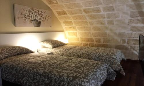 吉诺萨La Ginestra Affittacamere的一间卧室设有两张床和石墙