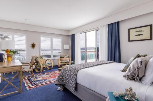 悉尼沃森海湾精品酒店的卧室配有一张床、一张书桌和窗户。