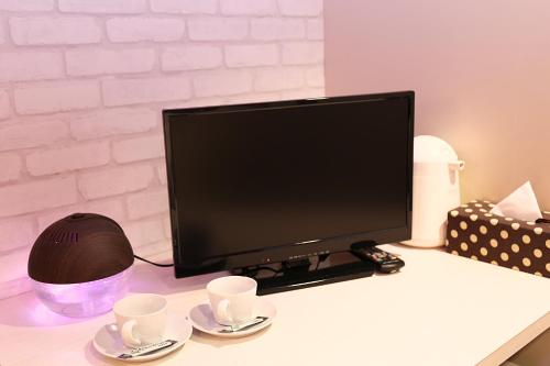 白马村HOTEL 24sweets HAKUBA的一张桌子上装有两杯的电脑显示器