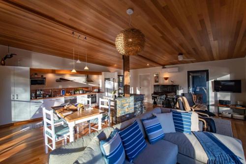 Adventure BayAdventure Bay Beach House的一间带蓝色沙发的客厅和一间厨房