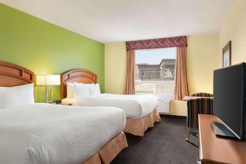 汤普森汤普森戴斯套房酒店的酒店客房设有两张床和一台平面电视。