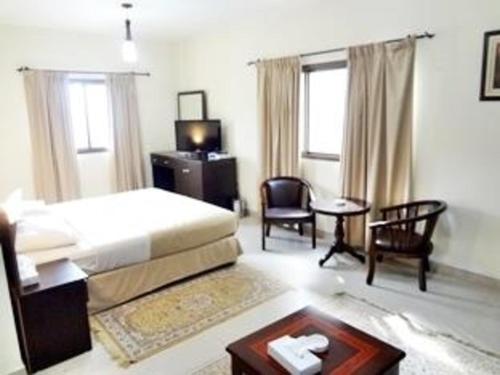 马斯喀特海豚酒店的卧室配有一张床和一张桌子及椅子