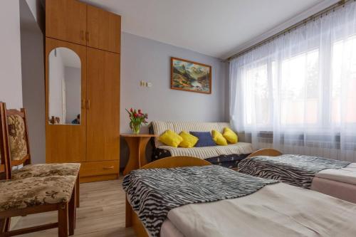 扎科帕内Willa Hostel Kasprowy的酒店客房,设有两张床和一张沙发