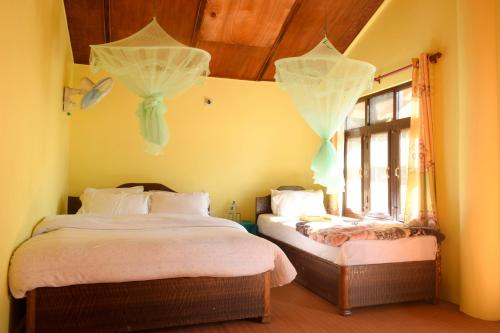 BhurkīāNature Safari Resort的一间卧室设有两张床和窗户。