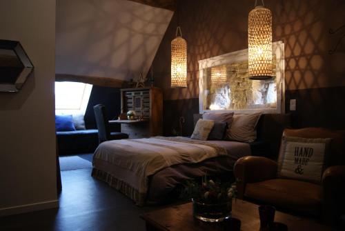 Jouhe德皮埃尔德卢米埃尔住宿加早餐旅馆的一间卧室配有一张床、一张沙发和一把椅子