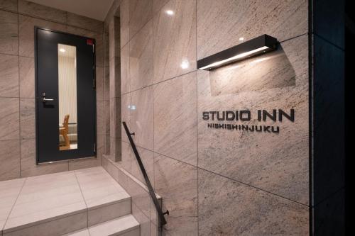 东京Studio Inn Nishi Shinjuku的带淋浴的浴室和玻璃门