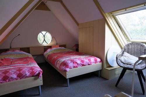 米德利B&B Waterland的一间卧室设有两张床、一个窗口和椅子