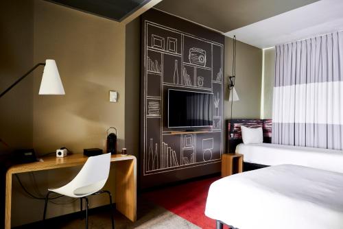 米兰宜必思米兰中心酒店的酒店客房设有一张床、一张书桌和一台电视机。