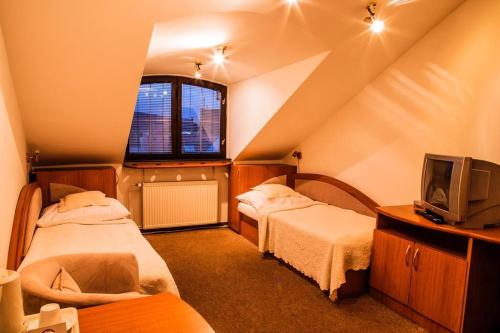 特伦钦Penzión Pod Hradom的阁楼间设有两张床和电视。