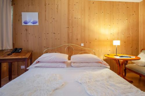 Saint-Étienne-de-Saint-Geoirs托迪耶尔农场酒店的木墙客房的一张床位