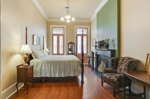新奥尔良格勒诺布酒店的一间卧室配有一张床、一个壁炉和一把椅子