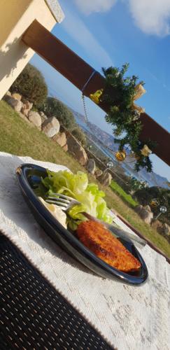马达莱纳Villa Sprafundu的桌上一盘带胡萝卜和生菜的食物