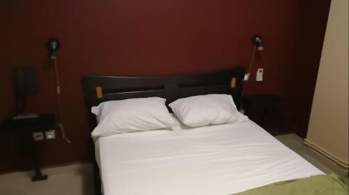 Bab EzzouarRoza Hotel的一张带白色床单和枕头的床