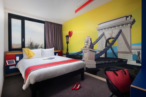布达佩斯ibis Styles Budapest Citywest的酒店客房配有一张床和一个壁炉。