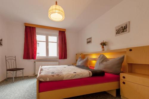 洛门Schloßblick的一间卧室设有一张床、一个窗户和一个吊灯。
