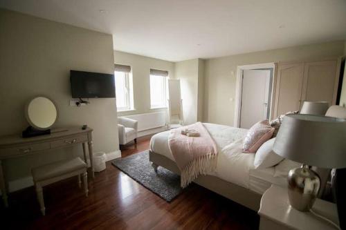 杜林West Haven House的一间卧室配有一张床、一张书桌和一面镜子