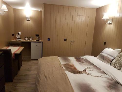 绍蒙－吉斯图LA RIVIERE DU BIEN ETRE的一间卧室配有一张大床,上面有绘画作品