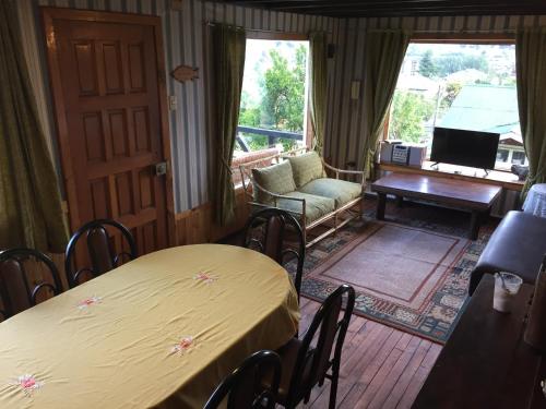 巴拉斯港Cabaña Hagemann的客厅设有2张桌子、1把椅子和1张沙发