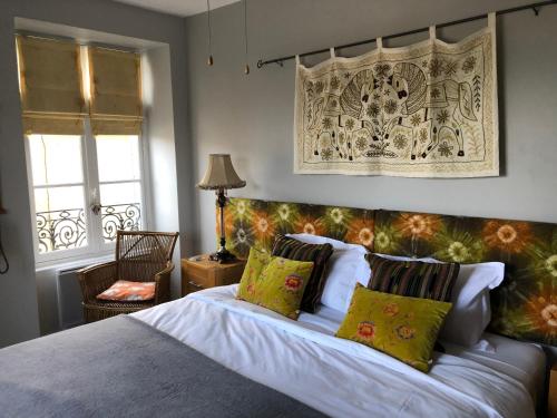蒙帕齐耶La Maison Anglaise的卧室配有带枕头的床铺和窗户。