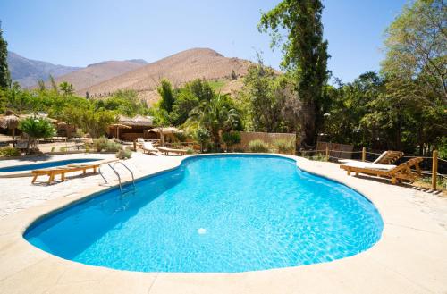 皮斯科艾齐Hotel El Tesoro de Elqui的一座位于山间度假村内的游泳池