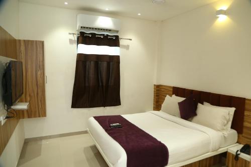 艾哈迈达巴德Shree Akshar Restaurant and Hotel的酒店客房设有床和窗户。
