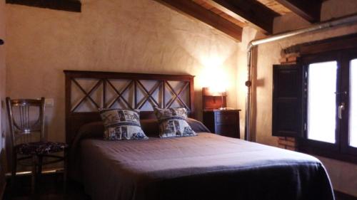 奥萨德蒙铁尔Casa Rural La Ossa的一间带一张大床的卧室,位于带窗户的房间内
