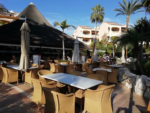 福恩吉罗拉Club La Costa World Resort的一间带桌椅和遮阳伞的餐厅