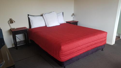 奥托罗杭阿棕榈阁汽车旅馆的一间卧室配有红色的床和2个床头柜