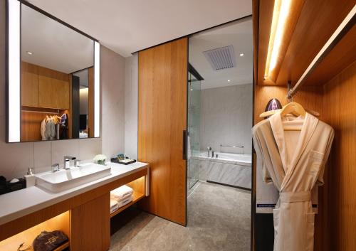 广州广州天河体育中心希尔顿欢朋酒店（广交会期间免费提供接驳巴士）的浴室配有盥洗盆和浴缸。