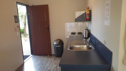 奥托罗杭阿棕榈阁汽车旅馆的一间带水槽和炉灶的小厨房
