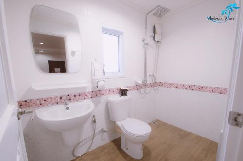 涛岛奥可坦广场酒店的一间带卫生间、水槽和镜子的浴室