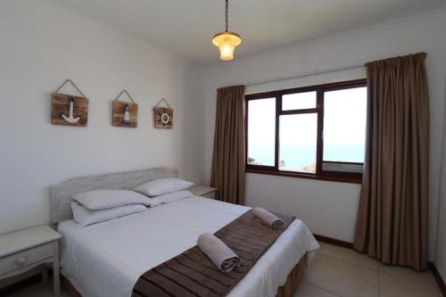普利登堡湾Villa Granada的一间卧室设有一张大床和一个窗户。