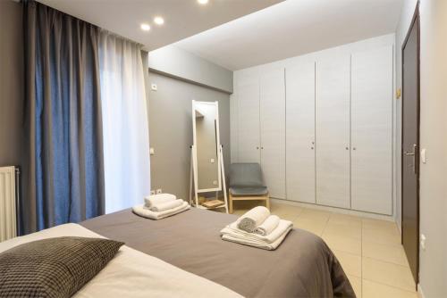 雅典M&D Luxury Suites in central Athens的一间卧室配有一张床,上面有两条毛巾