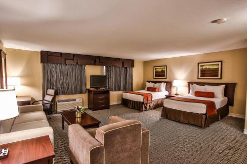 拉斯维加斯Tuscany Suites & Casino的酒店客房,设有两张床和一张沙发
