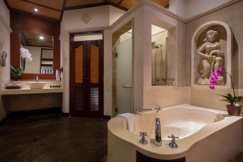 努沙杜瓦Bali Tropic Resort & Spa - CHSE Certified的带浴缸和盥洗盆的大浴室