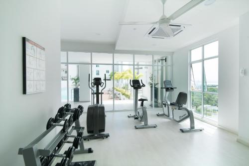 乔治市Straits Garden Suites, Georgetown的一间健身房,里面设有心肺功能训练器,房间设有窗户