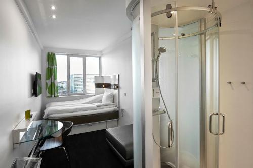哥本哈根Wakeup Copenhagen - Bernstorffsgade的带淋浴的浴室和客房内的一张床