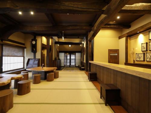 白川村Onyado Yuinosho的餐厅设有木制天花板、桌子和长凳