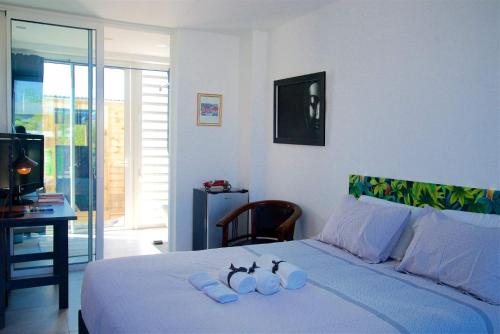 圣皮埃尔Maison TONGA piscine jaccuzi的一间卧室配有一张床,上面有两条毛巾
