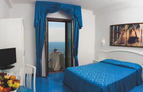 维耶特里德尔梅尔沃切酒店的一间卧室配有蓝色的床和镜子