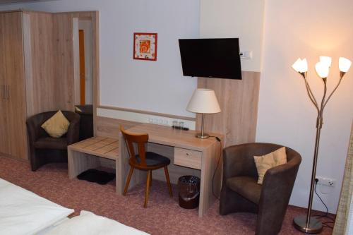巴特德里堡厄歇尔酒店的酒店客房配有书桌和2把椅子