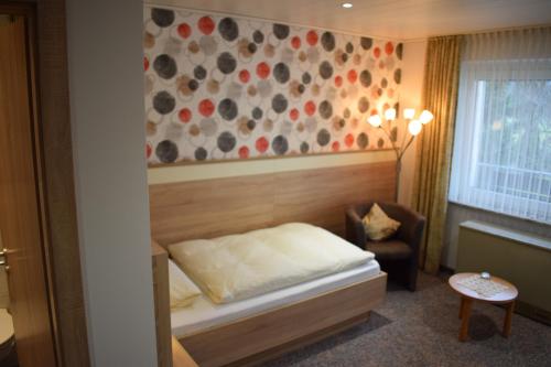 巴特德里堡厄歇尔酒店的一间小卧室,配有一张床和一把椅子