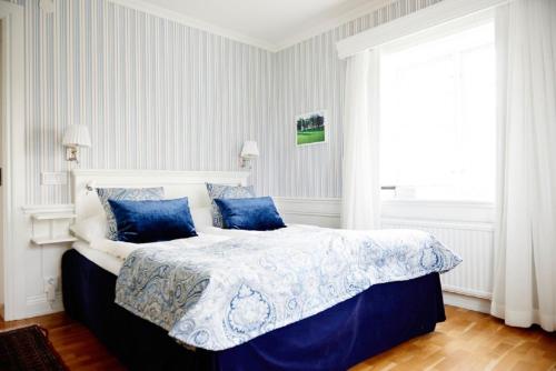 舍夫德Knistad Herrgård的一间卧室配有一张带蓝色枕头的大床