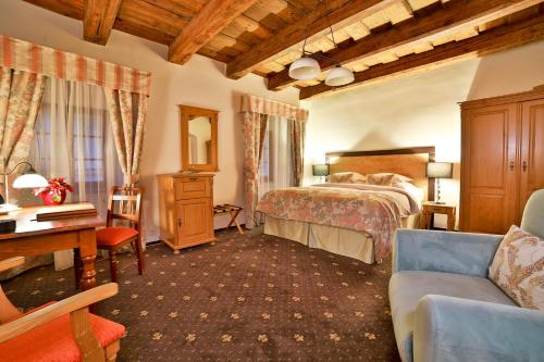 布拉格Questenberg Hotel的一间卧室配有一张床、一张桌子和一张沙发