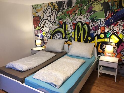 莫尔斯Wondervolles zuhause auf Zeit的色彩缤纷的墙壁前设有两张床的房间