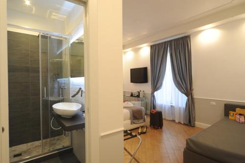 罗马My Suites Piazza di Spagna的一间带水槽的浴室和一张位于客房内的床